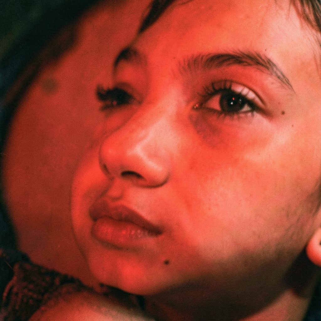 Candid documentary photograph of a person in warm interior light